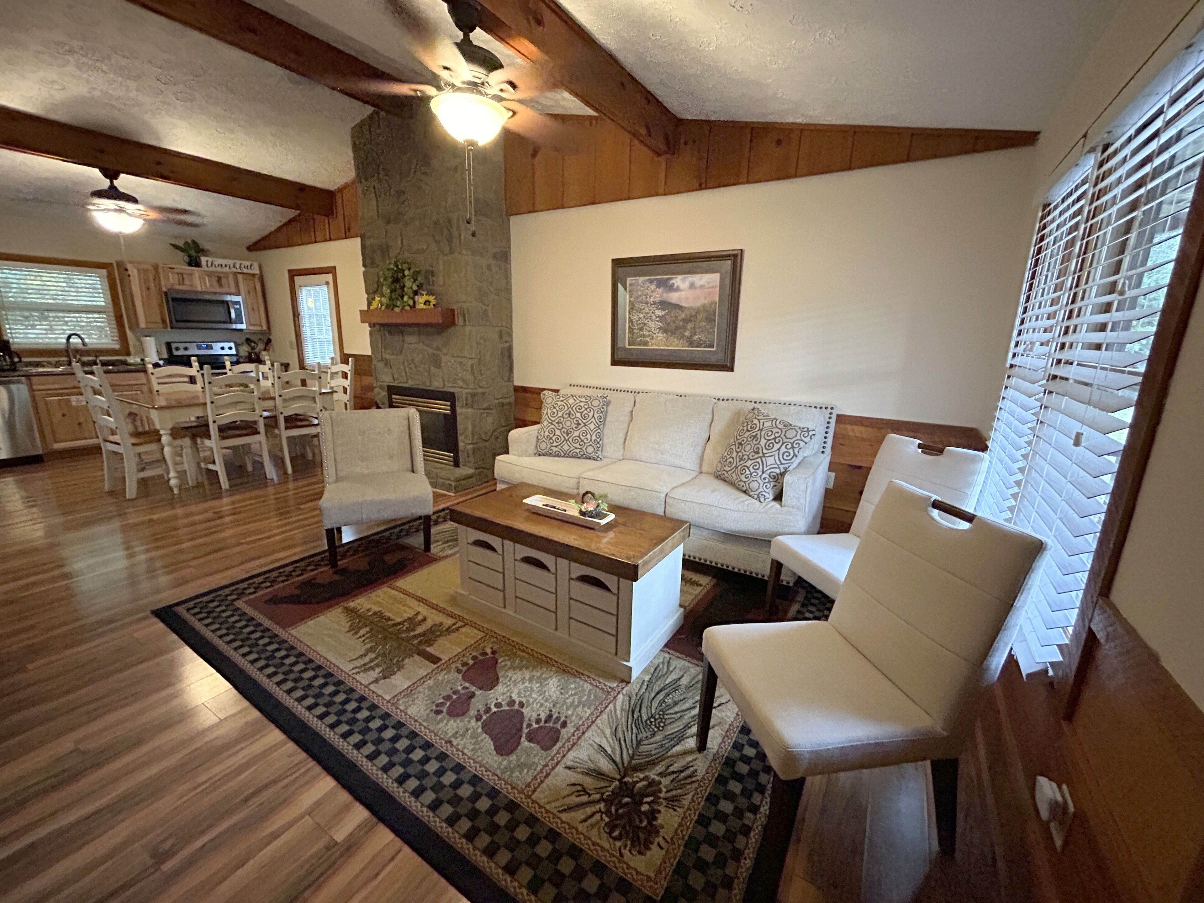 A spacious living area with a fireplace, a dining table with chairs, and a sofa.