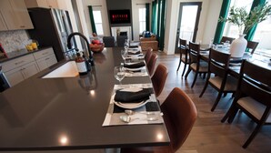 Een moderne eetruimte met een lange tafel voor zes personen, omringd door houten stoelen.