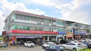 A multi-story building with signage for 'KUCHING TRANSIT INN' and 'CURRY HOUSE' on the ground floor.