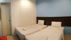 A hotel room with two beds, a red chair, and a door. - Kuching Transit Inn (Kuching)