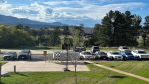 A parking lot with cars and a clear view of mountains in the background.