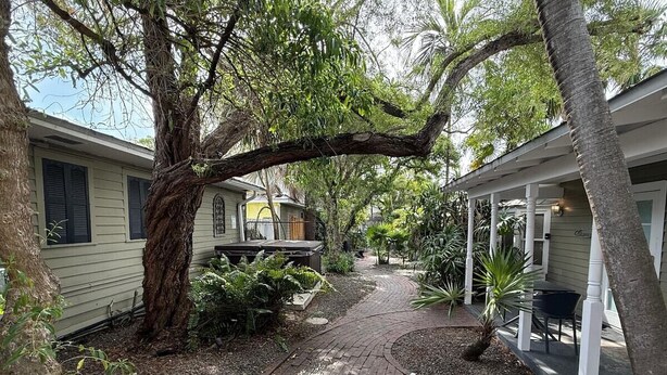 Un chemin menant à un bâtiment doté d’un espace extérieur abrité avec des sièges.