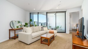Ein modernes Wohnzimmer mit einer Couch, einem Couchtisch und einer TV-Konsole.