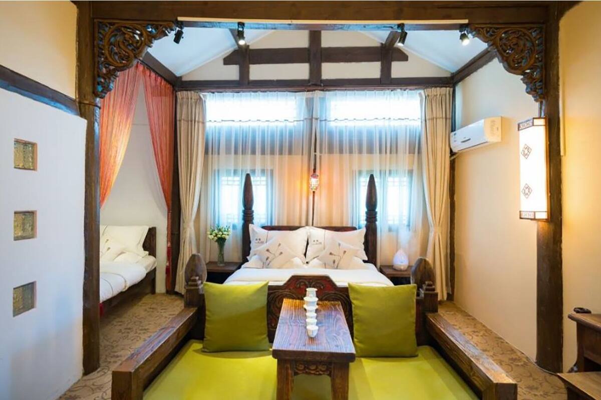 A traditional room with a bed, a small table, and a chair.