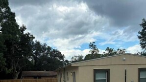 A single-story building with a paved walkway leading to the entrance. - Private studio near downtown (St. Augustine)