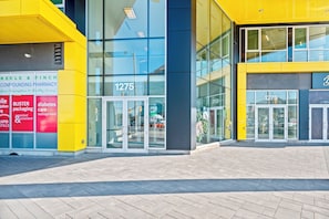 Welcome to 1275, a building with a clear view of the interior through its large glass windows and doors.