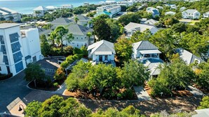 A residential area with houses, a large white building, and a view of the ocean.