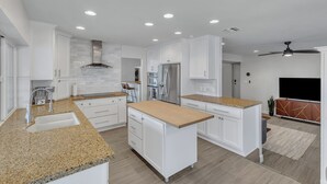 A modern kitchen with white cabinetry, granite countertops, and built-in appliances. - Modern and Classy 4 Bdrm N. Scottsdale Retreat! (Scottsdale)