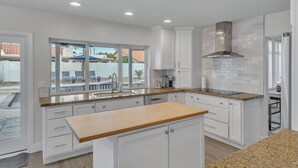 A modern kitchen with white cabinets, granite countertops, and a large island. - Modern and Classy 4 Bdrm N. Scottsdale Retreat! (Scottsdale)