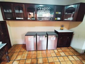 Kitchen area with a refrigerator, stove, and sink, featuring ample storage and a convenient countertop.