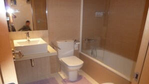 A bathroom with a sink, toilet, and bathtub. - Ten minutes from the beach, luxury apartment in the center of Rosas (Roses)