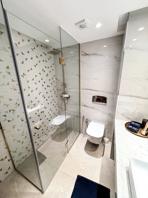 A modern bathroom with a glass-enclosed shower, a toilet, and a sink. - Paradis Citadin (La Marsa)