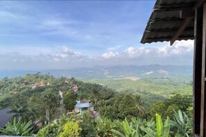 A view from a balcony overlooking a lush landscape with a small building in the foreground. - Sankara Garden (Seremban)