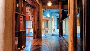 A wooden hallway with a ceiling light, wooden walls, and a view into another room. - Sankara Garden (Seremban)