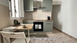 A compact kitchen with a dining area, a sink, and a coffee machine. - Lucky Corner - Elegant Stay (Taranto)