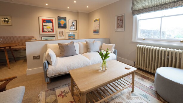A living room with a sofa, coffee table, and a window with a view. - Light filled Apartment - newly renovated (London)
