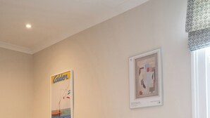 A bedroom with a bed, a vase with flowers, and two framed artworks on the wall. - Light filled Apartment - newly renovated (London)