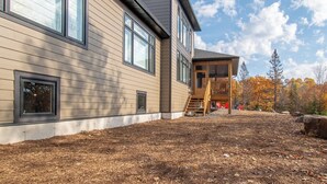 A modern two-story house with large windows and a wooden deck. - Muskoka Hills - Four Bedroom Cottage, Sleeps 8 (Huntsville)