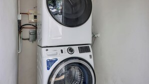 A stacked washer and dryer unit with a control panel, a vent system, and a power outlet.