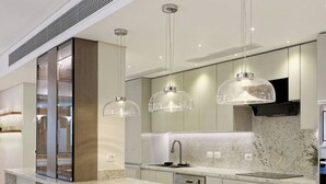 A modern kitchen with a marble countertop, stainless steel appliances, and pendant lighting. - Luxurious 3 bedrooms with Private Sauna & Jacuzzi in the prestigious Korba,Cairo (Cairo Governorate)