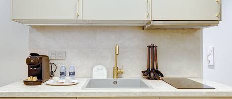 A modern kitchen with a built-in coffee maker, a sink, and a dishwasher.