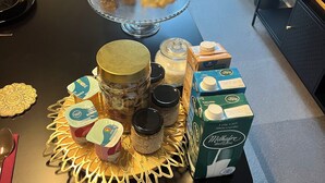 A table with food items and a glass dome cover.