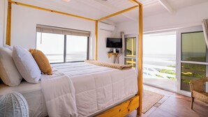 A bedroom with a four-poster bed, a ceiling fan, a TV, and a view of the outdoors. - Amazing mountain top villa! (Castries)