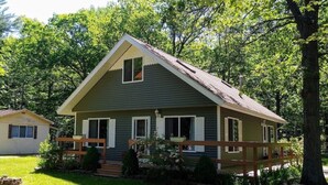 A two-story house with a front porch, a small attached garage, and a well-maintained lawn.