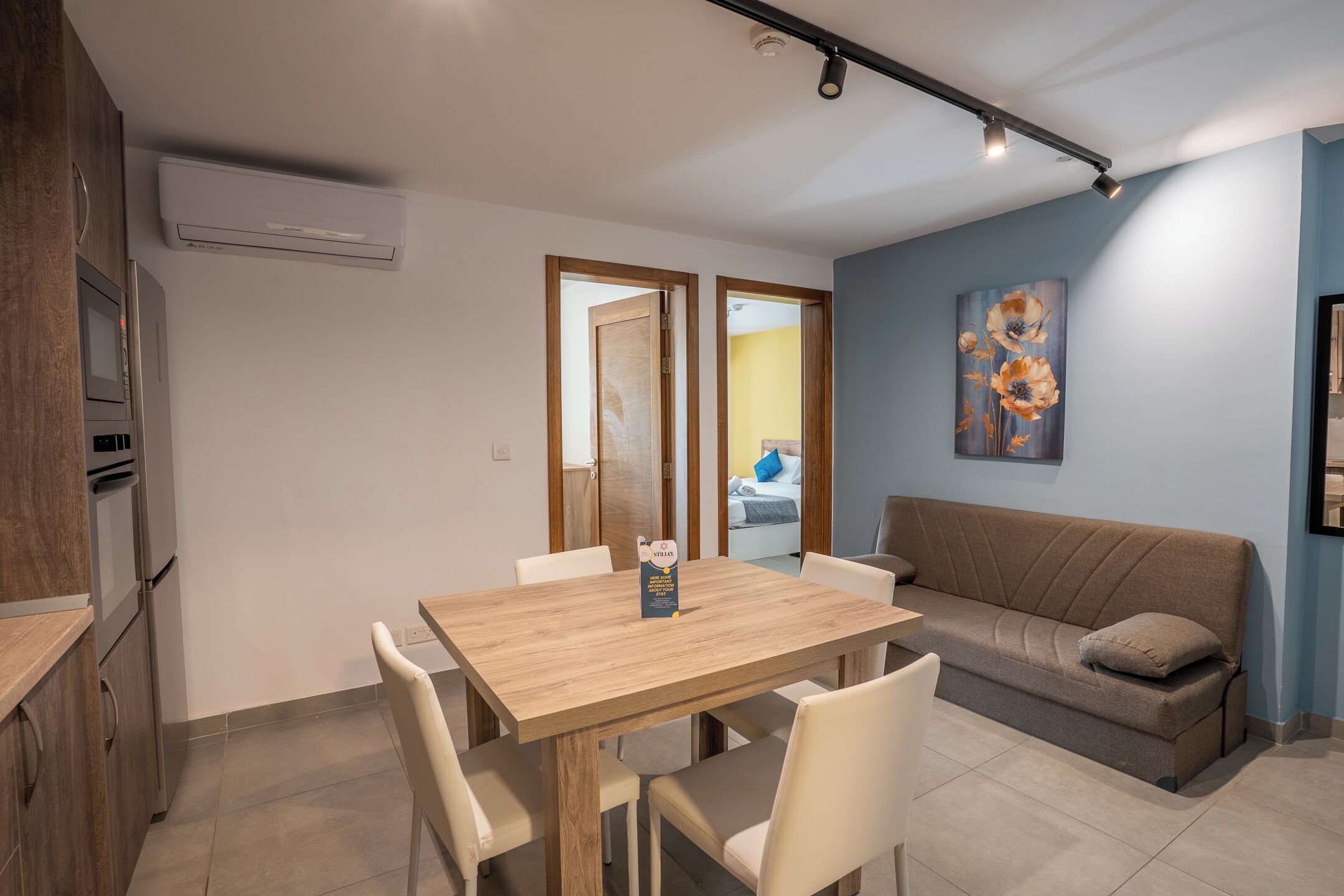 Una cocina moderna con microondas integrado, una mesa de comedor con sillas y un sofá.