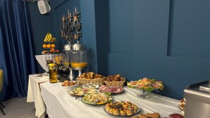 Una mesa de buffet con diversos alimentos y un dispensador de jugo.