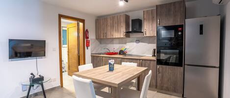 A modern kitchen with wooden cabinets, a built-in oven, and a refrigerator.
