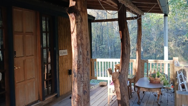Un rivestimento in legno con una zona coperta, una porta di legno e un cartello con scritto 'Woods'.