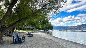 Une plage au bord du lac, avec des chaises longues et une jetée qui s’avance dans l’eau.