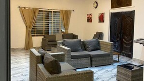 A living room with a sectional sofa, two armchairs, a coffee table, and a large window with curtains. - Sleep6-casa Blanca-privategarden-offstreet-kasoa (Kasoa)