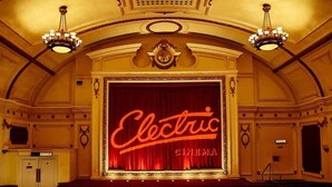 An interior of a cinema with a red curtain and the word "Electric" on it. - Colourful House 3 Bed Apt - Notting Hill (London)