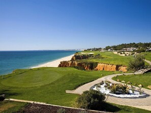 A golf course with a coastal view, a sandy beach, and a clear blue sky. - Thymbra Villa, Vale do Lobo, Algarve (Vale do Lobo)