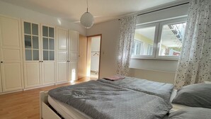 A bedroom with a bed, a wardrobe, and a window with curtains. - Beautiful vacation apartment "Karl May" in Elspe/Sauerland, approx. 65 sqm, for 1-4 persons (Lennestadt)