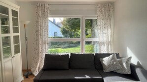 A room with a window, a sofa, and a lamp. - Beautiful vacation apartment "Karl May" in Elspe/Sauerland, approx. 65 sqm, for 1-4 persons (Lennestadt)