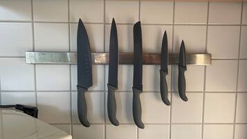 Una cocina con un soporte para cuchillos que contiene cinco cuchillos.