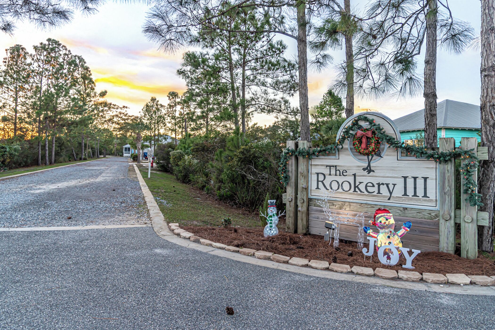 A sign for The Rookery III with a Christmas wreath and a snowman decoration.