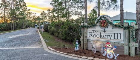 A sign for The Rookery III with a Christmas wreath and a snowman decoration.