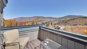 Een balkon met uitzicht op bergen en herfstkleuren.