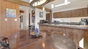 Een moderne keuken met houten kastjes, een granieten aanrechtblad en roestvrijstalen apparatuur.