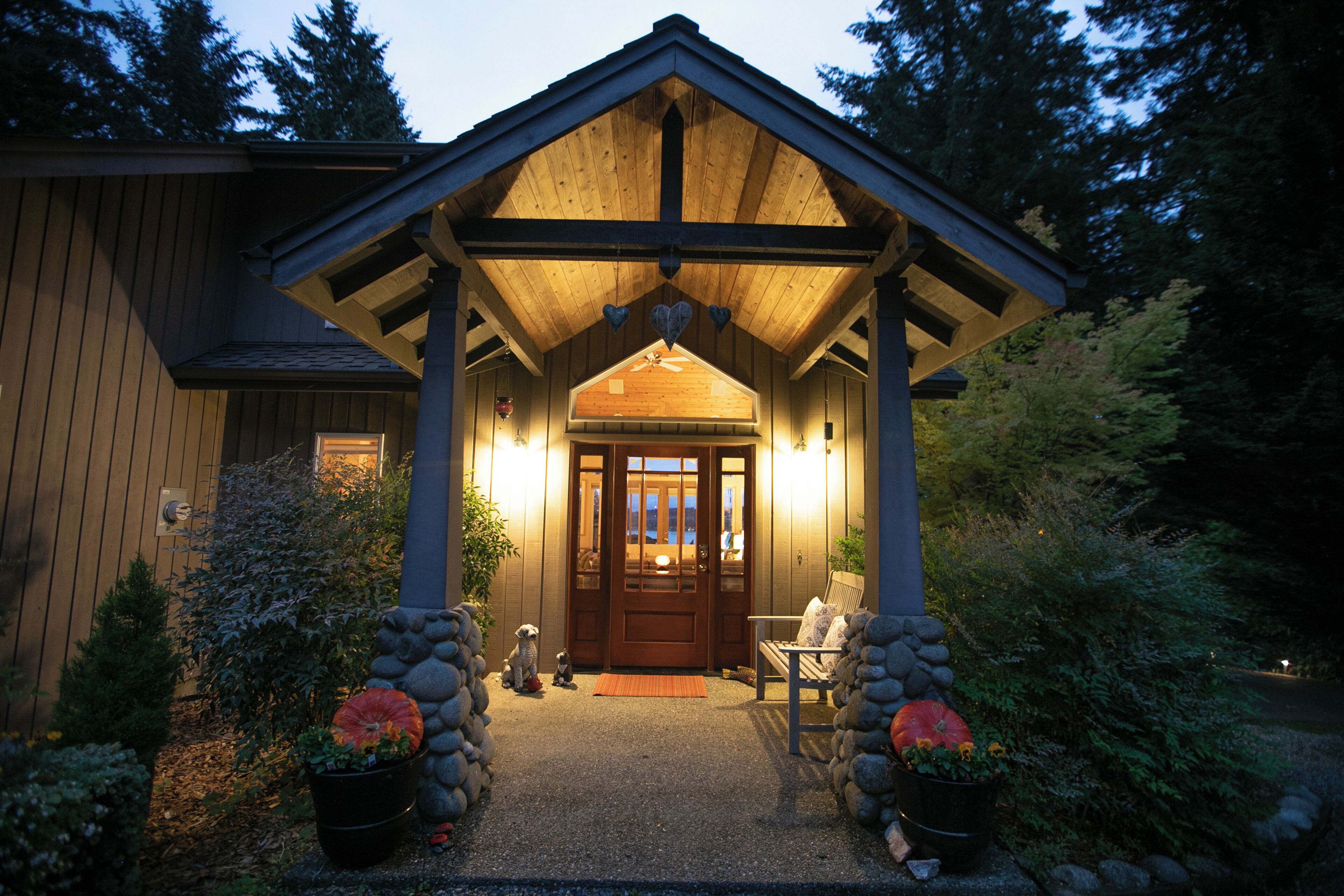 A wooden cabin with a porch, a door, and a bench.