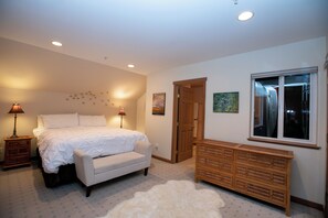 A bedroom with a bed, bedside lamps, a dresser, a door, and a window. - Charming 3-bedroom house in Vashon with cool AC breeze (Vashon)