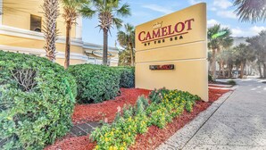 Une enseigne d’hôtel avec l’inscription « CAMELOT BY THE SEA » et, en dessous, une autre enseigne indiquant « CHAMBRES LIBRES ».