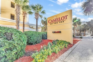 Une enseigne d’hôtel avec l’inscription « CAMELOT BY THE SEA » et, en dessous, une autre enseigne indiquant « CHAMBRES LIBRES ».