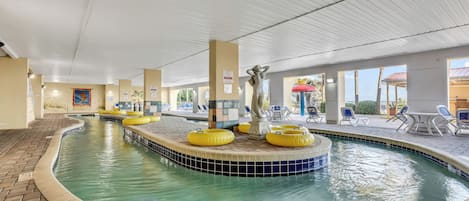 An indoor swimming pool with yellow floating rings, a statue, and a tiled edge.