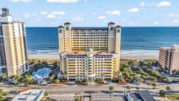Un hôtel à étages, doté d’une tour centrale et offrant une vue sur la plage.