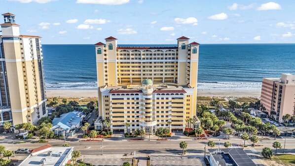 Un hôtel à étages, doté d’une tour centrale et offrant une vue sur la plage.